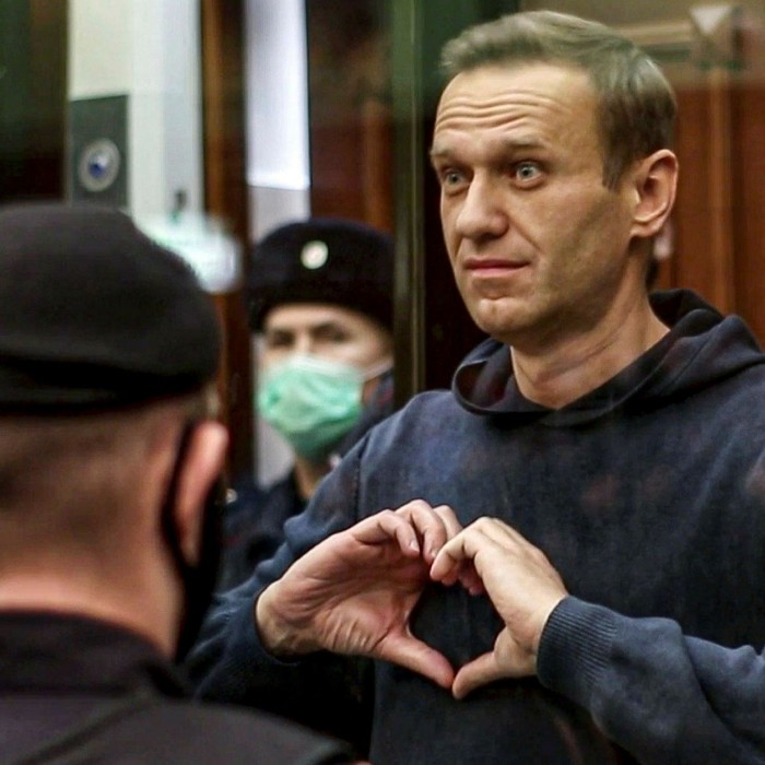 Alexei Navalny hace una señal con el corazón con su banda mientras está en la jaula durante una audiencia en el Tribunal Municipal de Moscú en febrero de 2021.