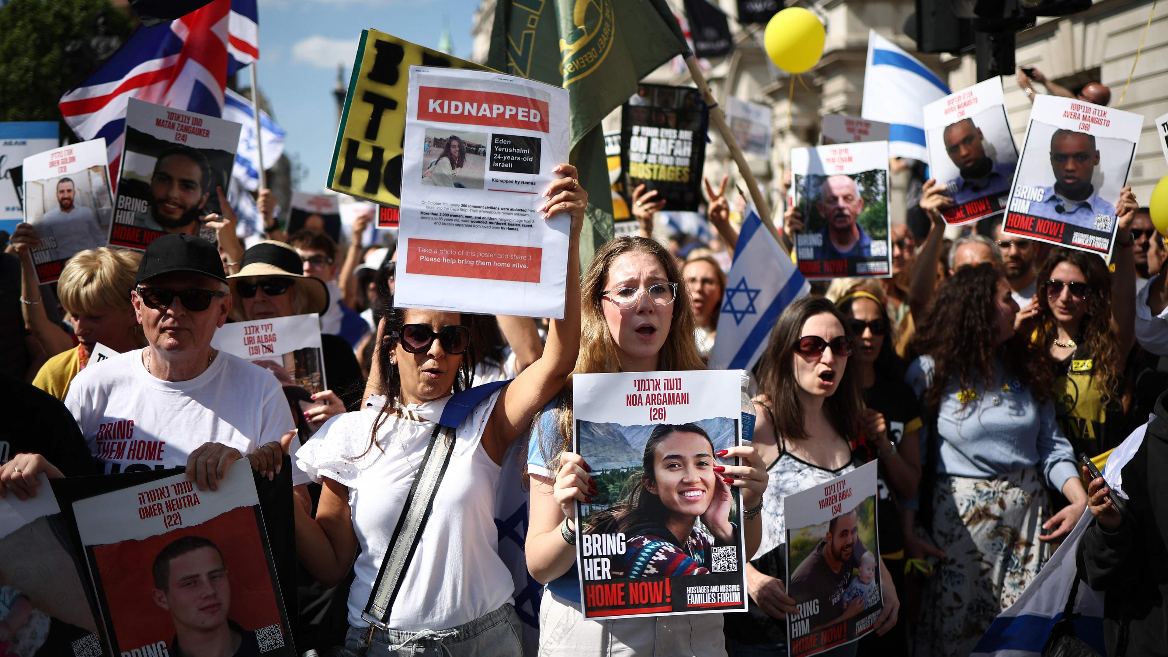 Manifestantes con pancartas, incluida una con la rehén Noa Argamani. 