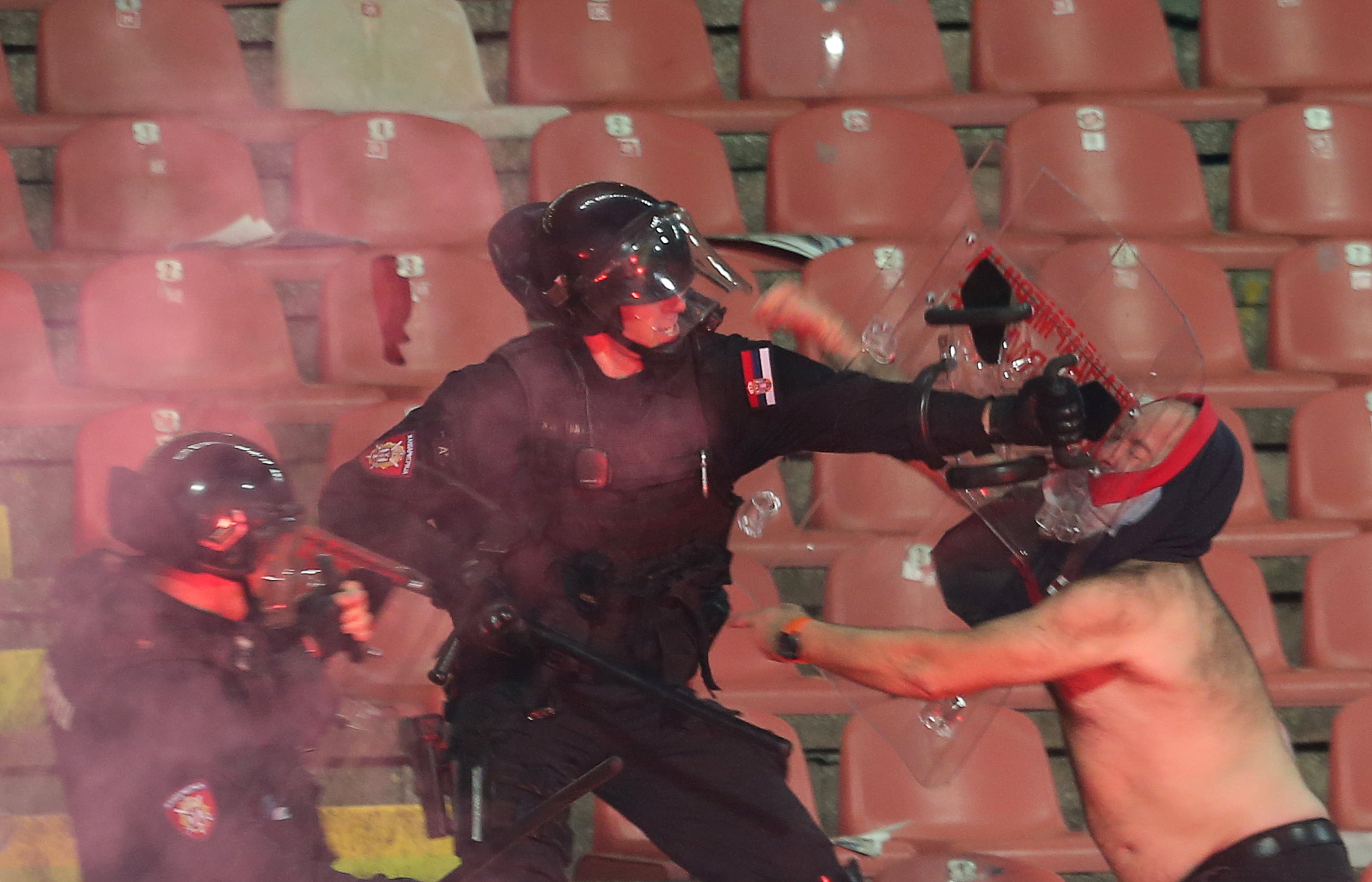 Un aficionado serbio se enfrenta a la policía durante un partido entre el Estrella Roja y el Partizan en Belgrado en 2018.