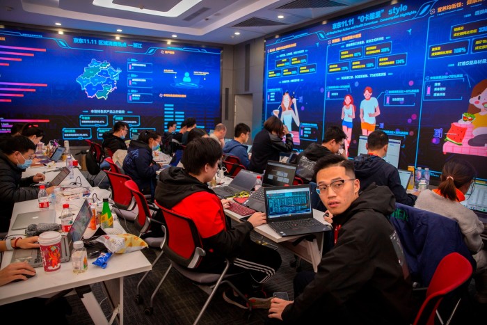 Los trabajadores monitorean las computadoras en un centro de comando en la sede del minorista en línea JD.com en Beijing.