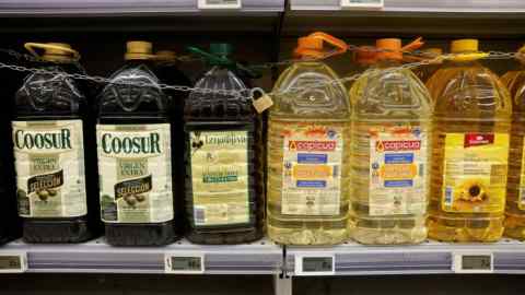 Botellas de aceite de oliva y aceite de girasol en un estante de supermercado