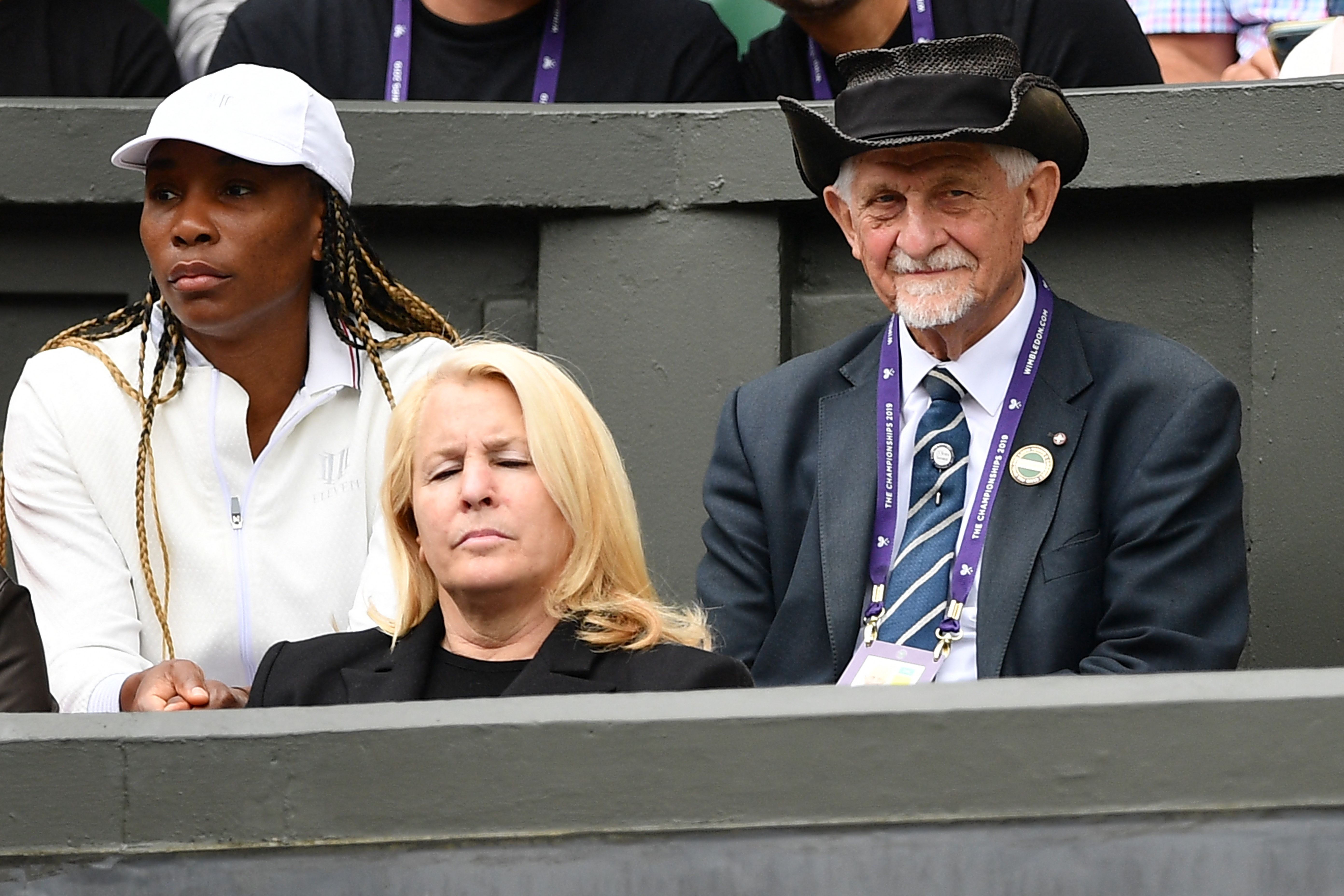   El veterano azafato David Spearing (derecha) ocupa su posición en la cancha central junto a la jugadora estadounidense Venus Williams (izquierda) en el palco familiar el octavo día del Campeonato de Wimbledon de 2019.