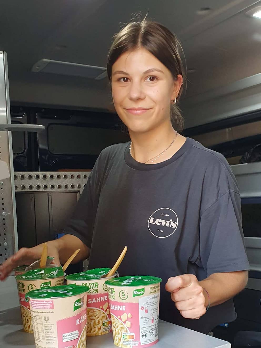 Además de sacos de dormir, colchonetas y crema solar, Antonia también reparte sopas calientes y agua en tetra packs desde la furgoneta azul.