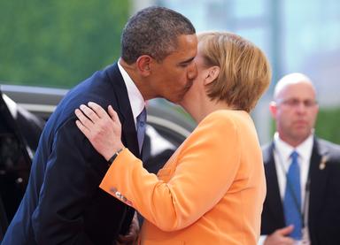 Barack Obama y Angela Merkel se besan en la mejilla.