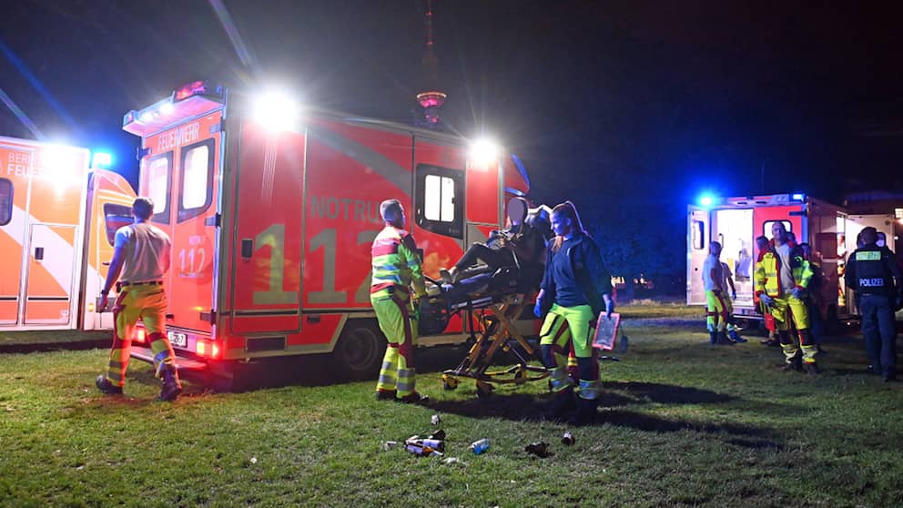 Una mujer es llevada a una ambulancia.