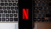 Historial de títulos de Netflix: celular con logo N muerto en teclado de laptop