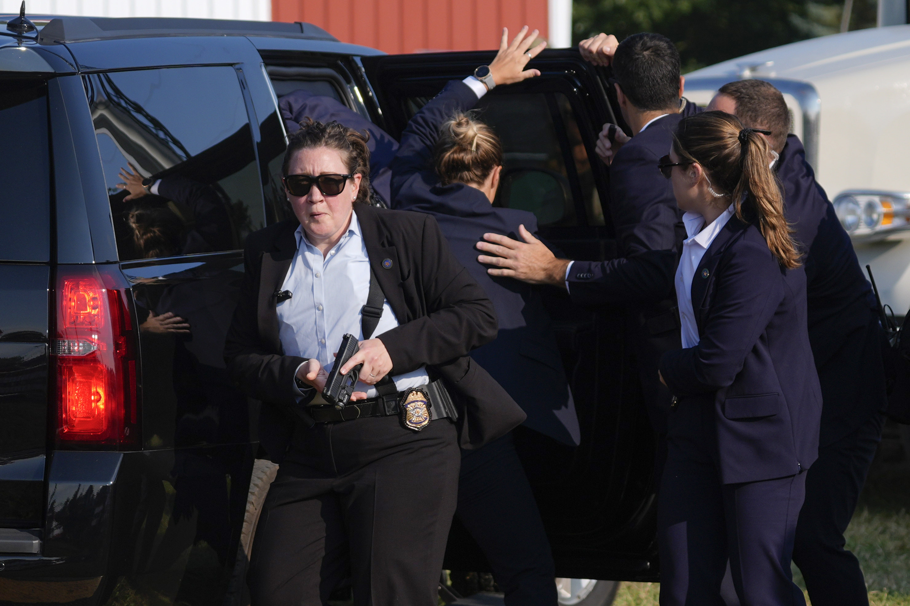 El candidato presidencial republicano, el expresidente Donald Trump, es rodeado por agentes del Servicio Secreto de Estados Unidos mientras lo llevan a un vehículo en un mitin de campaña.