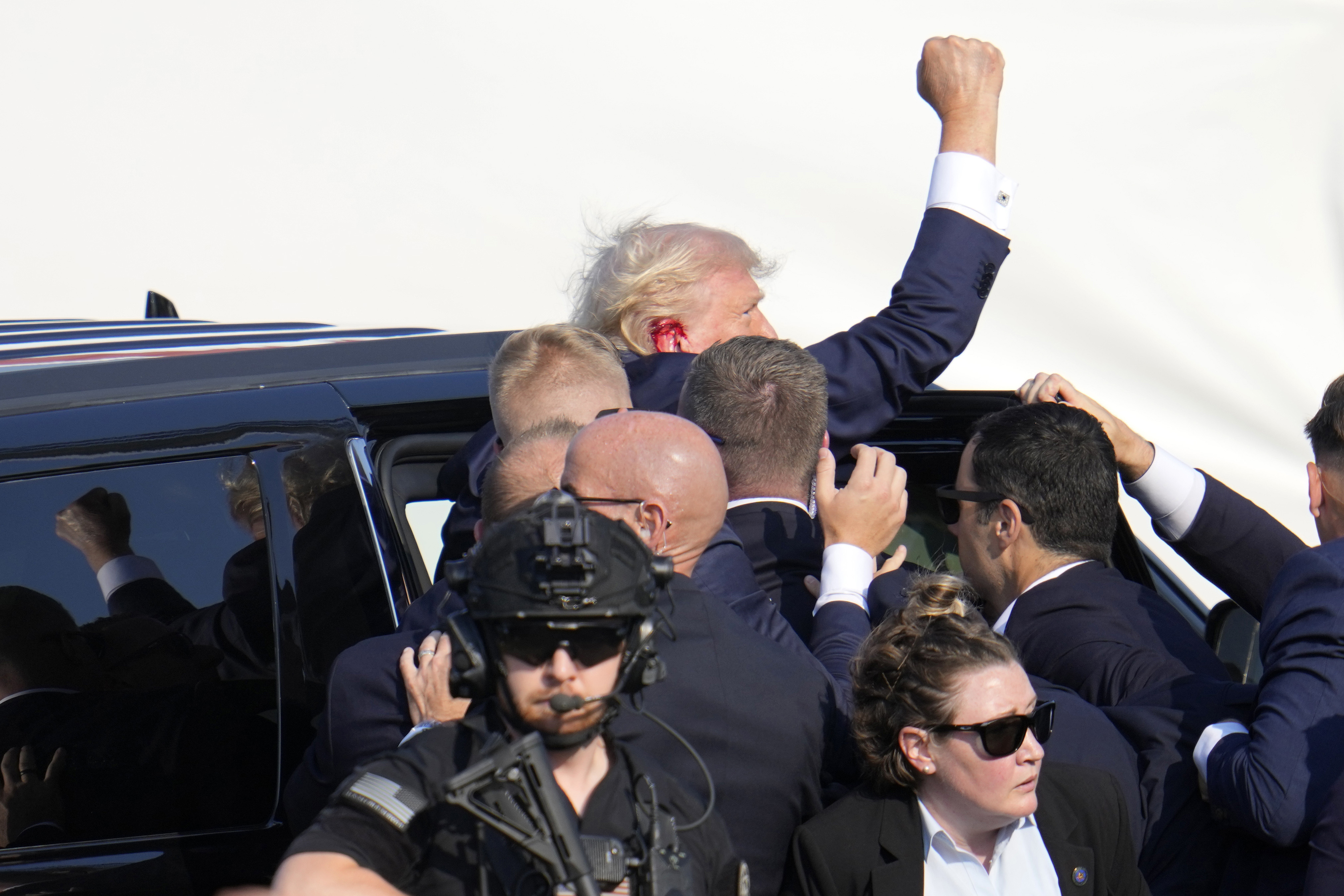 Trump fue llevado rápidamente a su auto mientras sostenía el puño en alto.