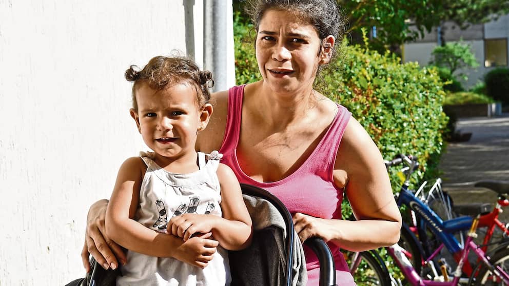 Haifa Chaafati (31) con su hija Aya (2) frente a la maloliente entrada de su casa. 