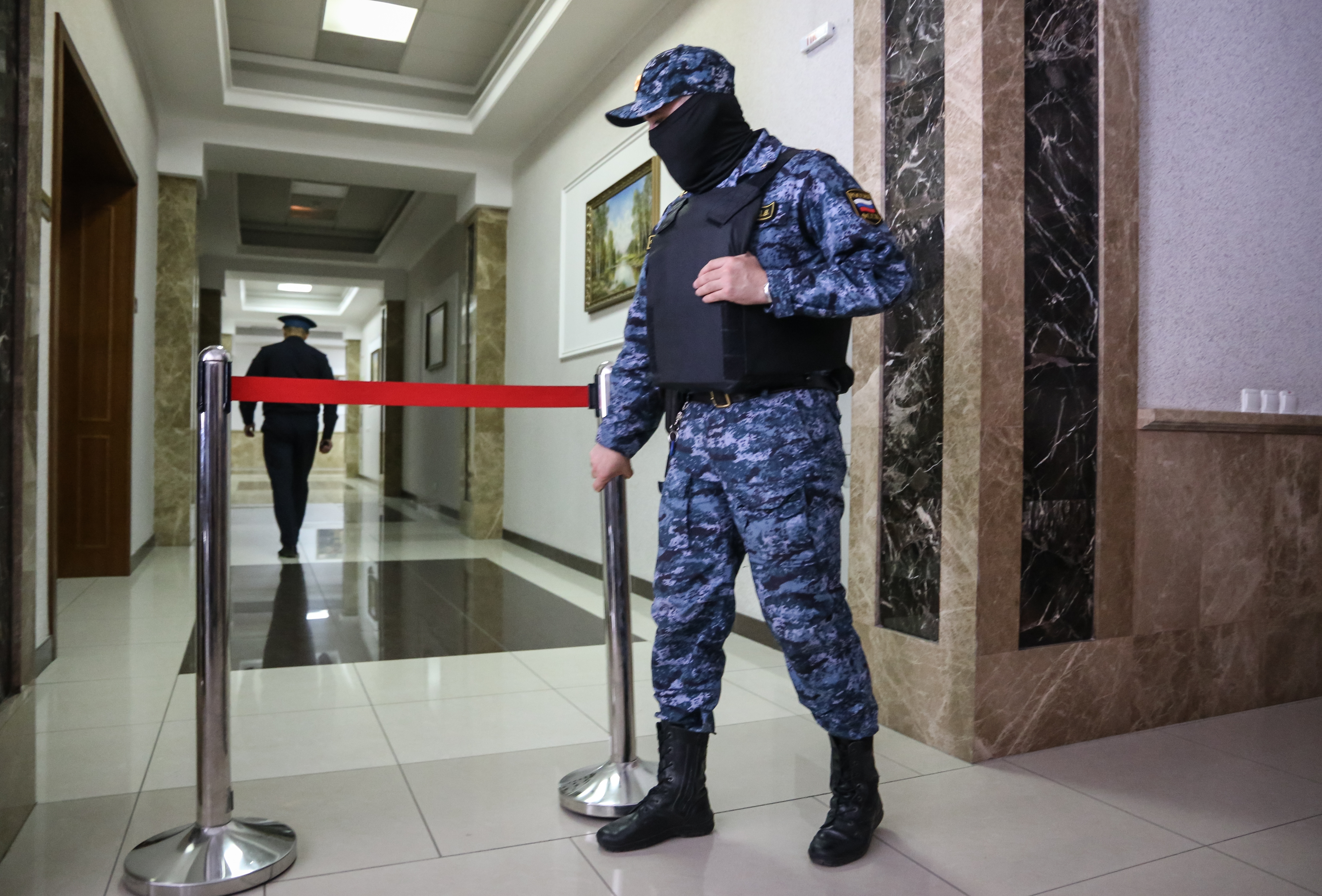 Un guardia enmascarado se encuentra hoy fuera de la audiencia a puerta cerrada en el tribunal en Rusia