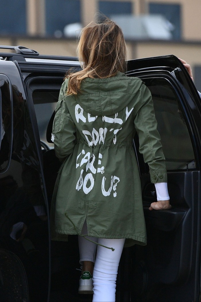 Una mujer que lleva una chaqueta con un eslogan en la espalda.