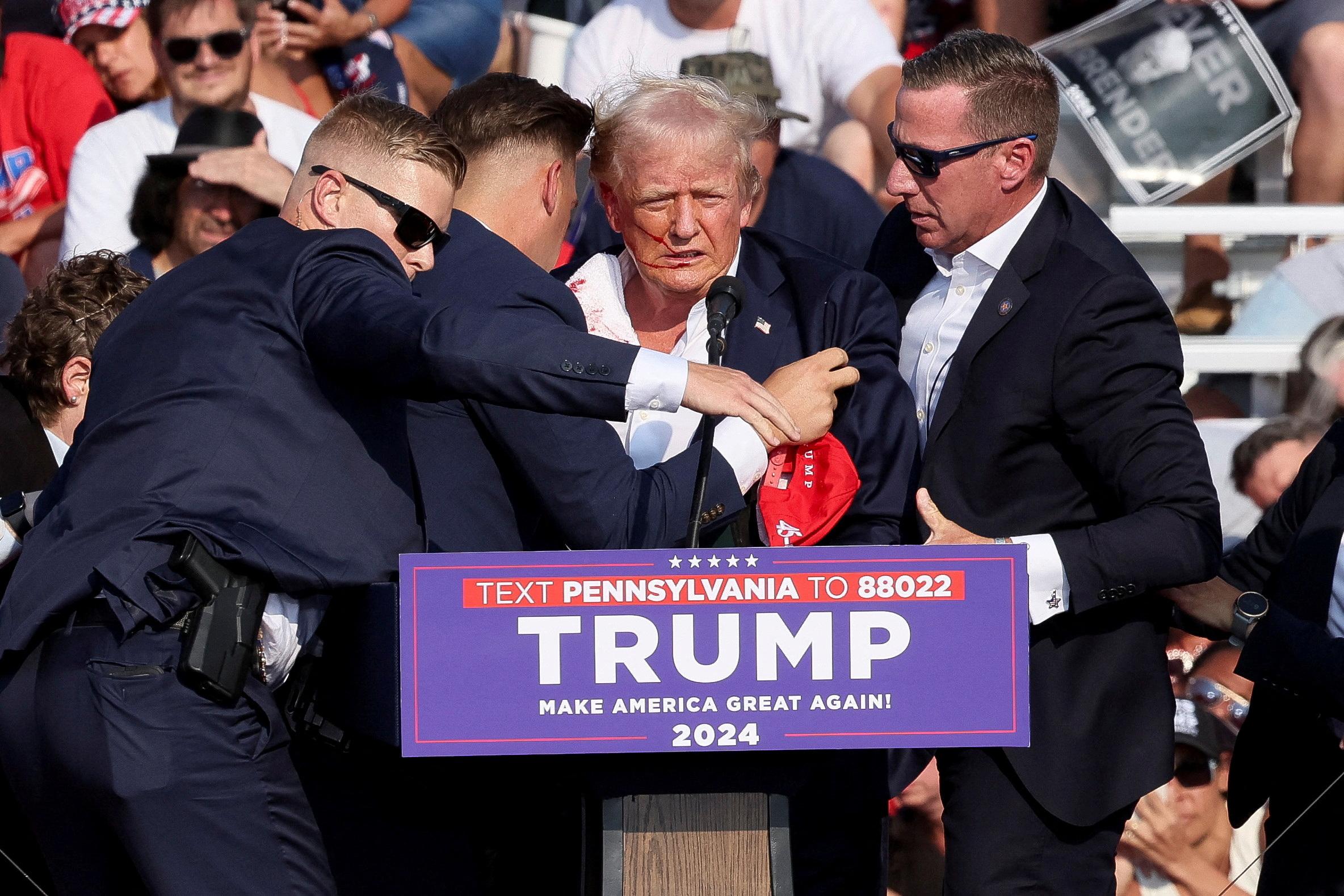El expresidente Trump fue visto rodeado por agentes del Servicio Secreto luego de que Crooks disparara en el escenario.