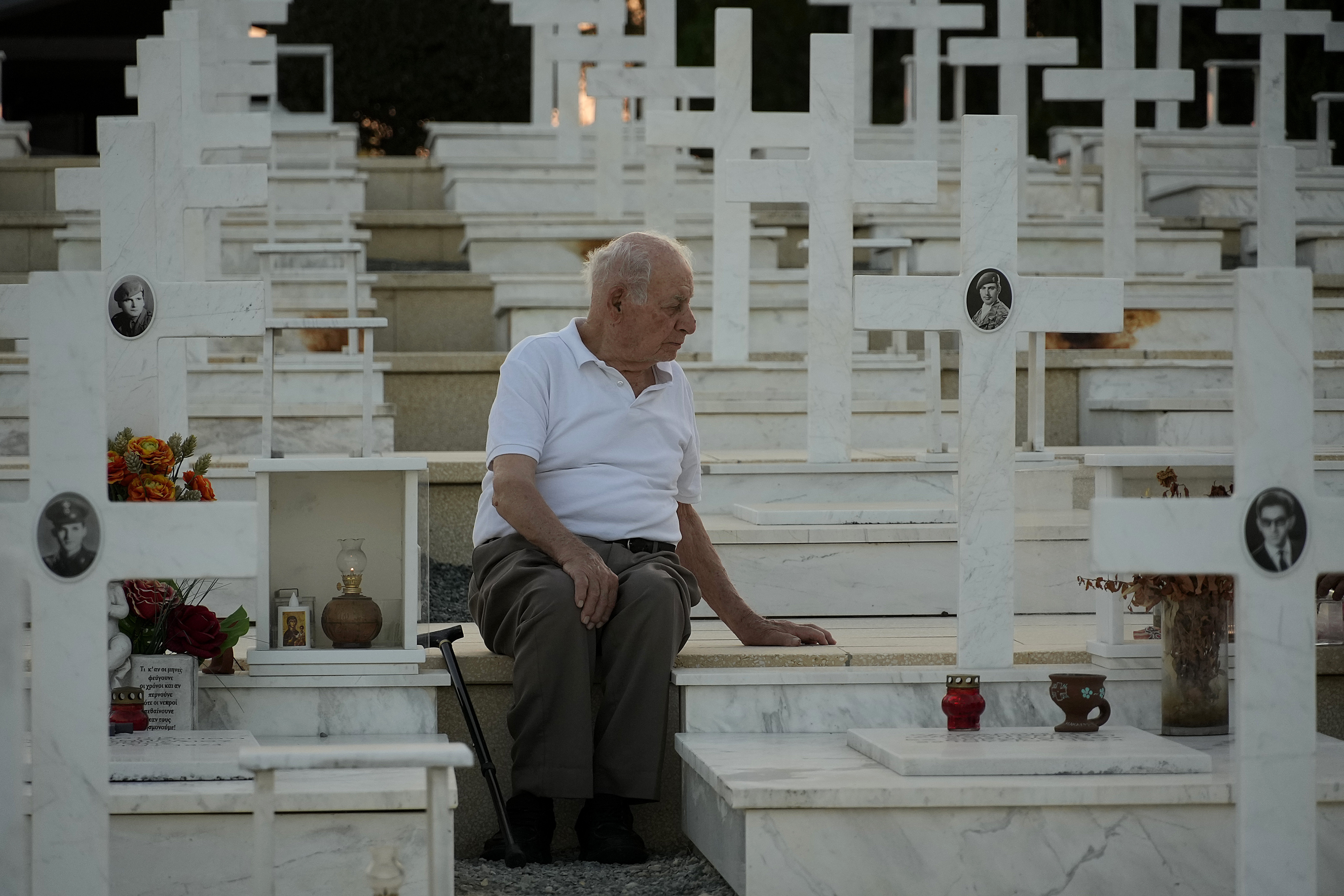 Loucas Alexandrou, de 94 años, se sienta junto a la tumba de su hijo que murió durante la guerra.
