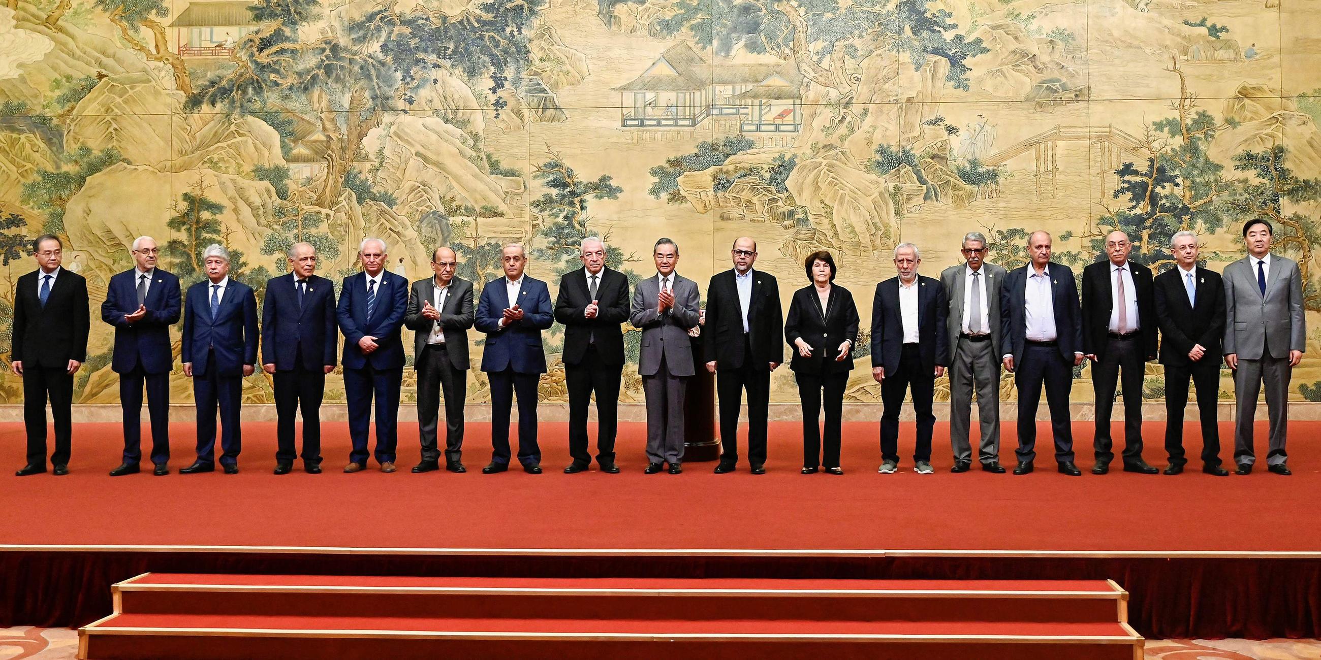 El Ministro de Asuntos Exteriores de Hina, Wang Yi (centro), posa para una fotografía de grupo con miembros de las facciones palestinas durante la firma de la 