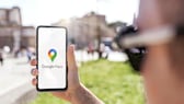 La persona sostiene un teléfono inteligente con Google Maps.