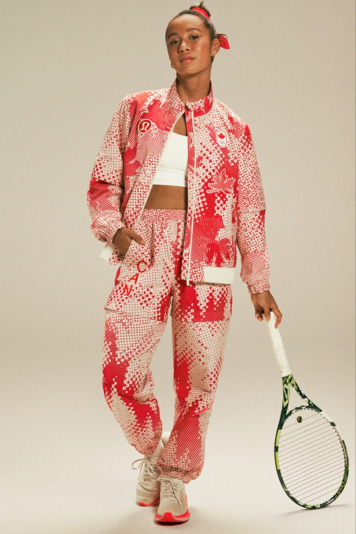 Una mujer con un chándal rojo y blanco con una raqueta de tenis en la mano.