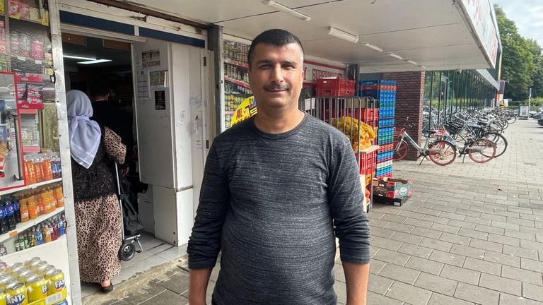 Ahmed Youssef, propietario de un supermercado, frente a su negocio (foto: Raymond Merkx).