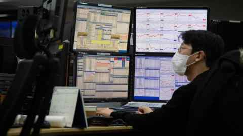 Un comerciante surcoreano trabaja frente a monitores