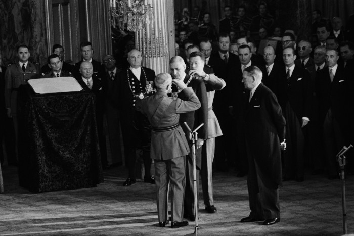 La ceremonia de investidura del recién elegido presidente francés Charles de Gaulle, en el centro, en enero de 1959, con su predecesor René Coty, a la derecha, observando.