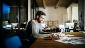 El hombre se sienta en la computadora portátil