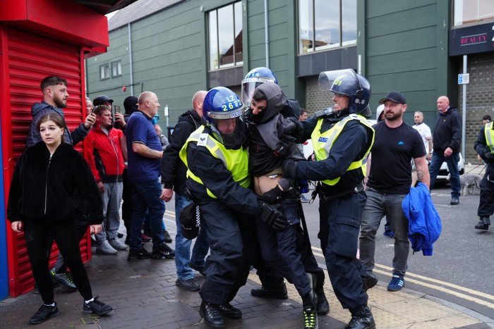 Un hombre es detenido por agentes de policía durante una protesta en Middlesbrough el domingo