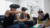 Tres mujeres juegan a la realidad virtual con controladores.