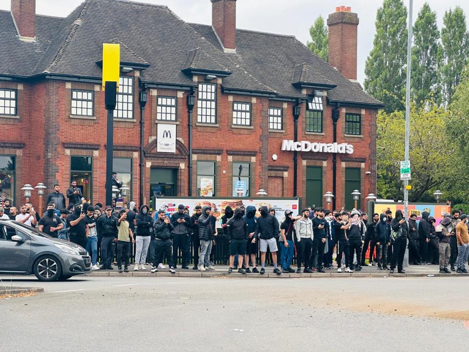 Una multitud se reúne fuera de McDonald's en Bordesley Green