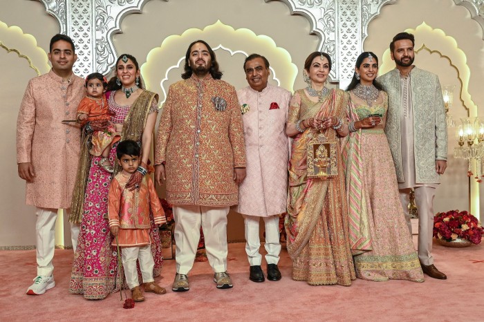 El jefe de Reliance Industries, Mukesh Ambani, en el centro, se encuentra entre su esposa Nita y su hijo Anant mientras los miembros de la familia posan para fotografías en las lujosas celebraciones de la boda de Anant.