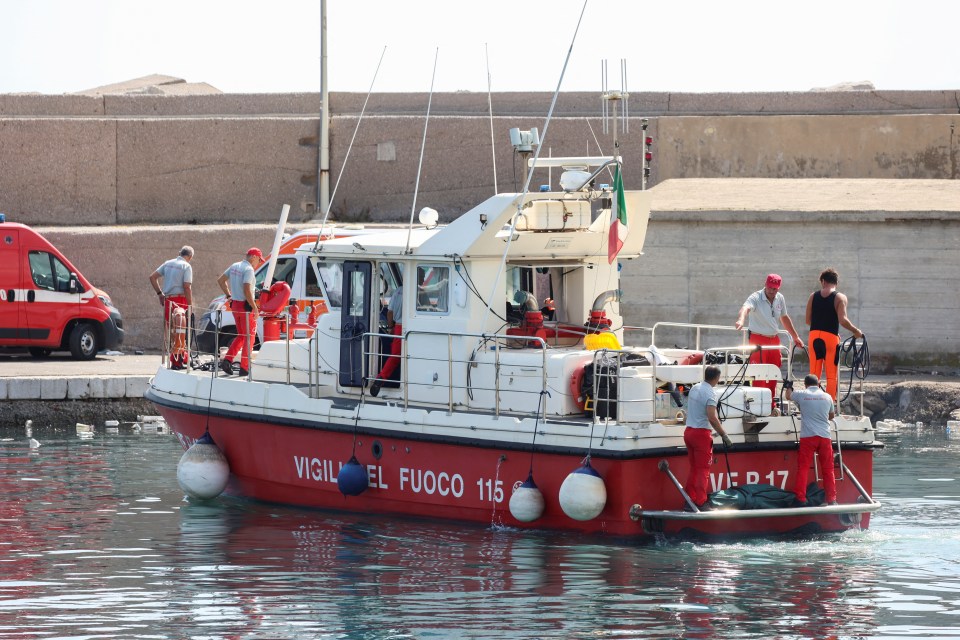 Los bomberos italianos transportan una bolsa para cadáveres en medio de la búsqueda