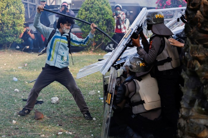 Manifestantes se enfrentan a la policía antidisturbios durante una protesta contra las controvertidas revisiones planeadas a la ley electoral frente al edificio del Parlamento de Indonesia en Yakarta