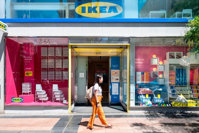 Una mujer pasa frente a una tienda Ikea. 