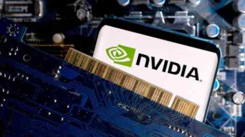 Logotipo de Nvidia en un teléfono, junto a la placa base de una computadora