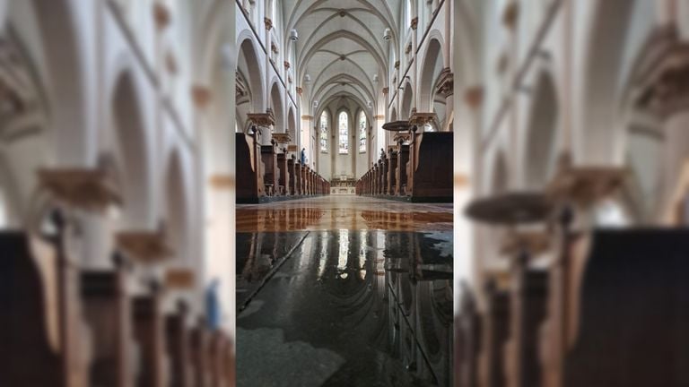 El agua de lluvia se acumula en un charco en el suelo de la iglesia de Houtse (foto: Miranda van Bragt)