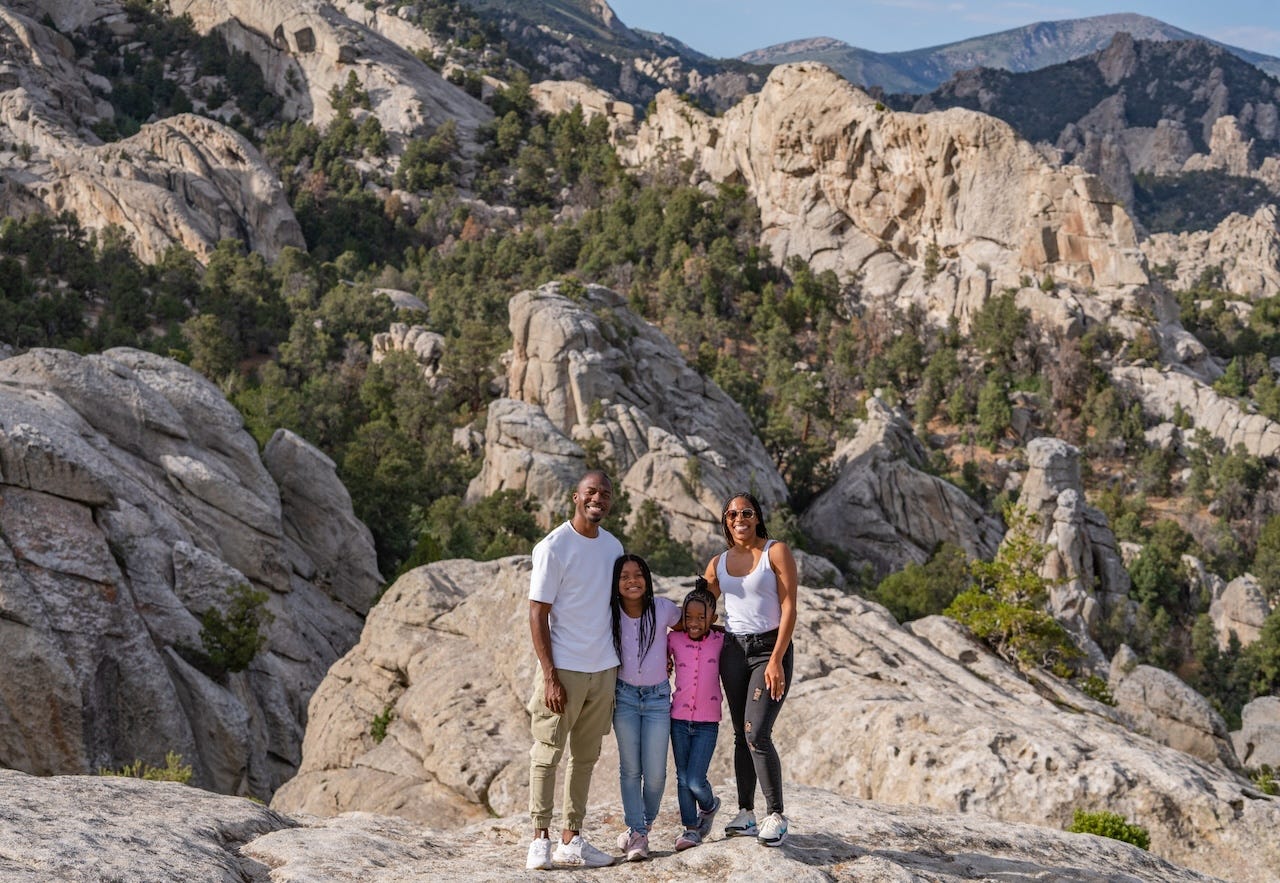 La familia Hambrick sonríe y se encuentra en un paisaje rocoso en el sur de Idaho.