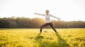 Mujer haciendo yoga en un prado.