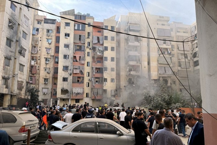 La gente inspecciona el lugar de un ataque israelí en los suburbios del sur de Beirut, Líbano