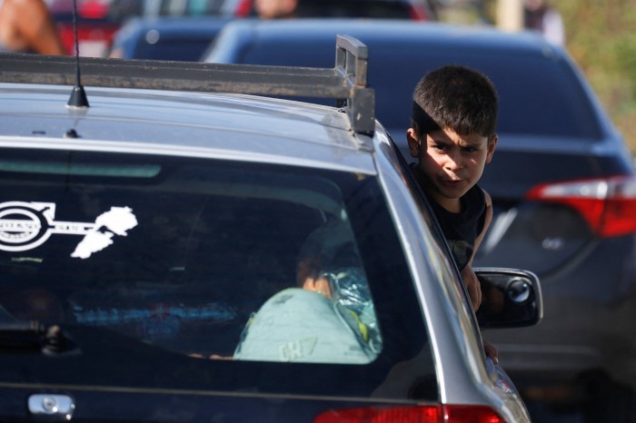 Un niño mira desde la ventanilla de un coche mientras la gente en medio del denso tráfico se dirige hacia el norte desde la ciudad costera de Sidón, en el sur del Líbano.