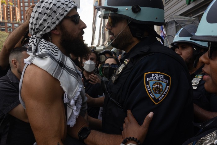 Un manifestante pro palestino y un policía de la ciudad de Nueva York se enfrentan