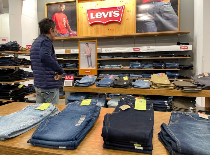 Un hombre mira una fila de ropa Levi's en una tienda de California.