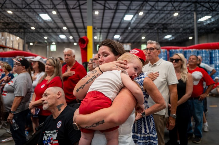 Elizabeth Issacs espera con su hijo pequeño antes de que el candidato presidencial republicano, el expresidente estadounidense Donald Trump, llegue a un mitin de campaña en Mint Hill, Carolina del Norte. 