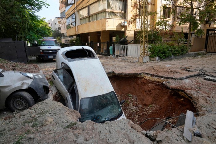 Un automóvil se encuentra en un cráter en los suburbios del sur de Beirut, el sábado 28 de septiembre de 2024. 