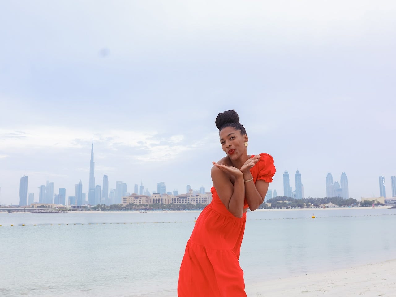 Monet Hambrick con un vestido largo de una sola manga en una playa de Dubai.