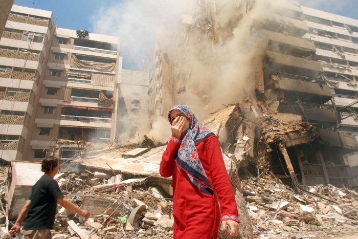 La gente pasa junto a edificios destruidos en Beirut