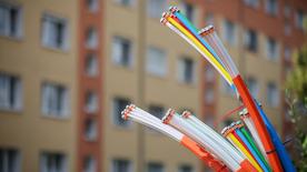 Los cables de fibra óptica sobresalen de la base de un armario de control