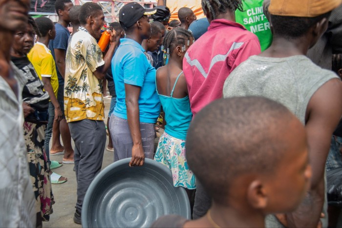 La gente espera una distribución de alimentos en un campamento de desplazados en la escuela Lycée Marie Jeanne en Puerto Príncipe el 2 de octubre.