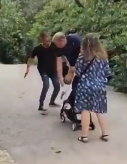 El hombre gira la mano hacia atrás para pretender abofetear al bebé.