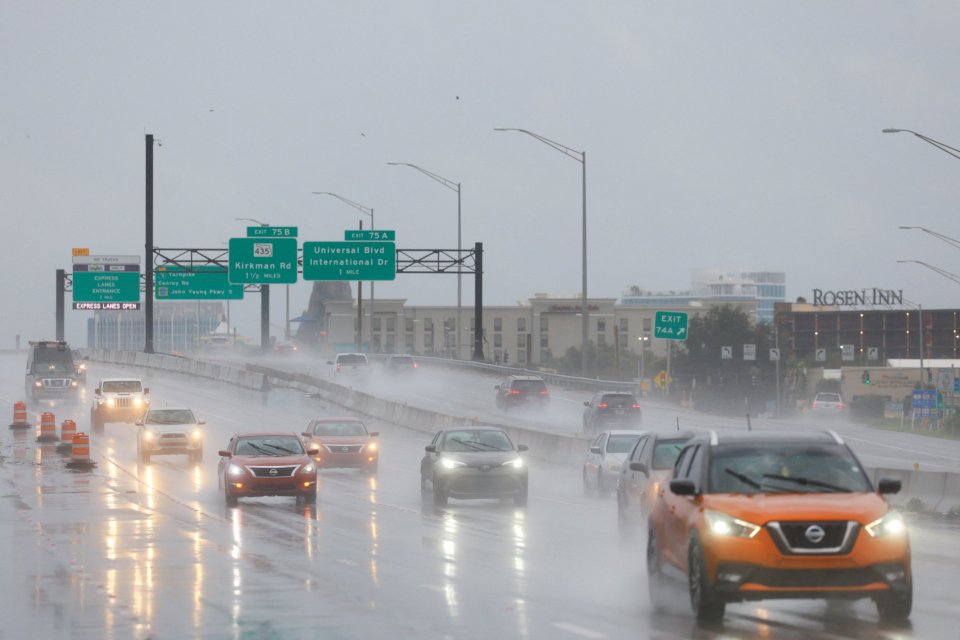 Los automóviles circulan durante las fuertes lluvias mientras el huracán Milton se acerca a tocar tierra en Orlando