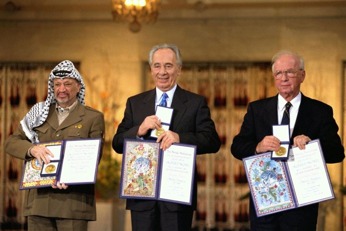 Yasser Arafat, Shimon Peres e Yitzhak Rabin exhiben sus Premios Nobel de la Paz 