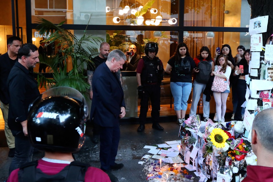 Geoff mira las masas de flores, tarjetas y velas que quedaron en honor a su hijo Liam.