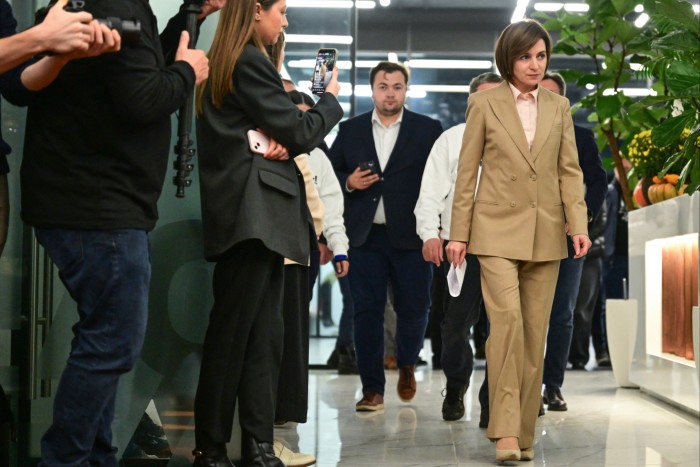 La gente observa cómo la presidenta Maia Sandu llega a una conferencia de prensa en la sede de su campaña en Chisinau.